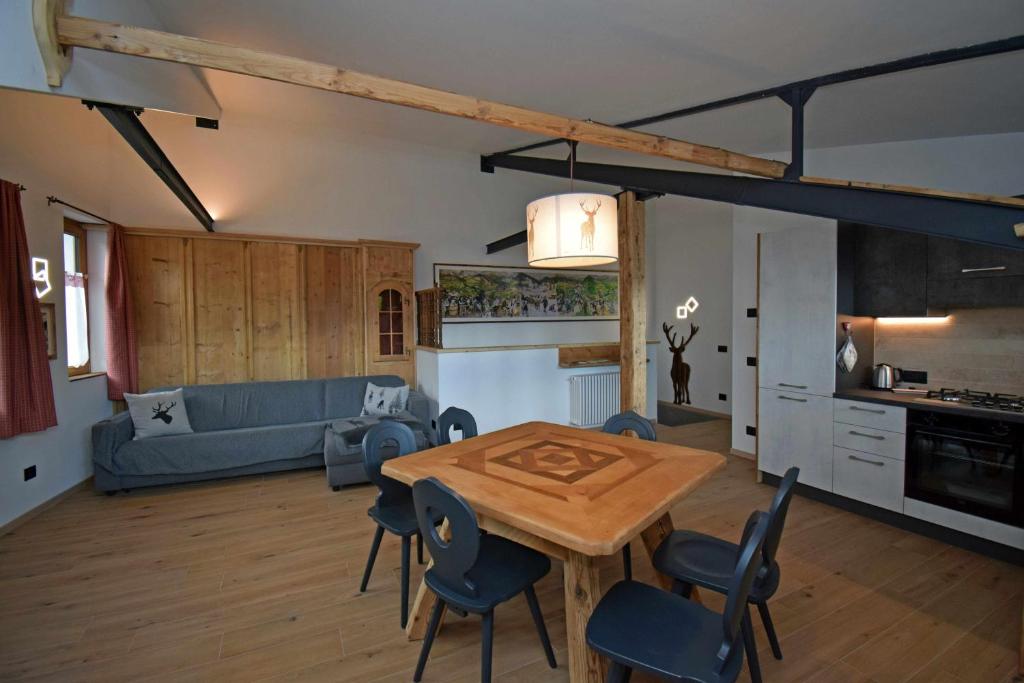 cocina y sala de estar con mesa de madera y sillas en Legno VecchioPadolaDolomitirustic e modern, en Padola