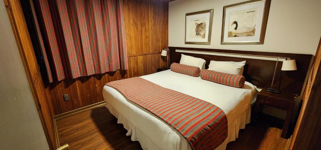 a hotel room with a bed with two pillows at Hotel y Cabañas Las Mellizas - Caja Los Andes in Los Ángeles