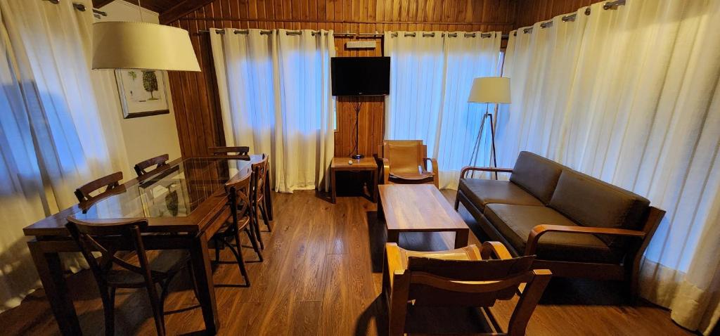 a living room with a couch and a table and chairs at Hotel y Cabañas Las Mellizas - Caja Los Andes in Los Ángeles