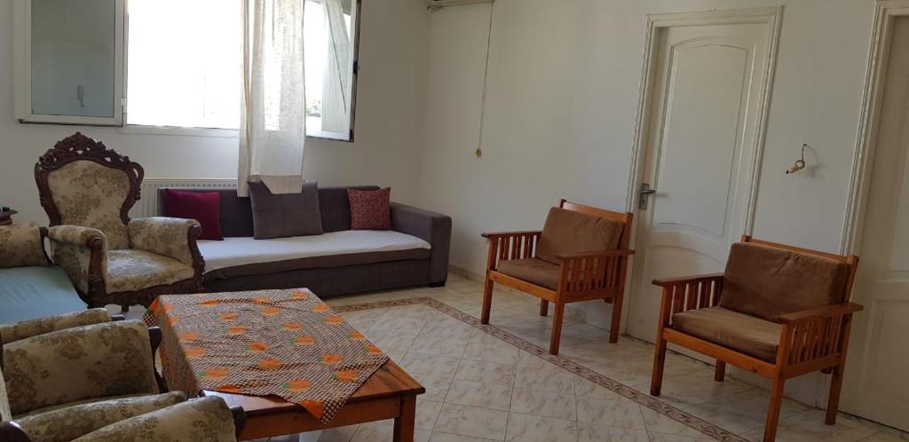 a living room with a couch and chairs and a table at Appartement S+2 in Sousse