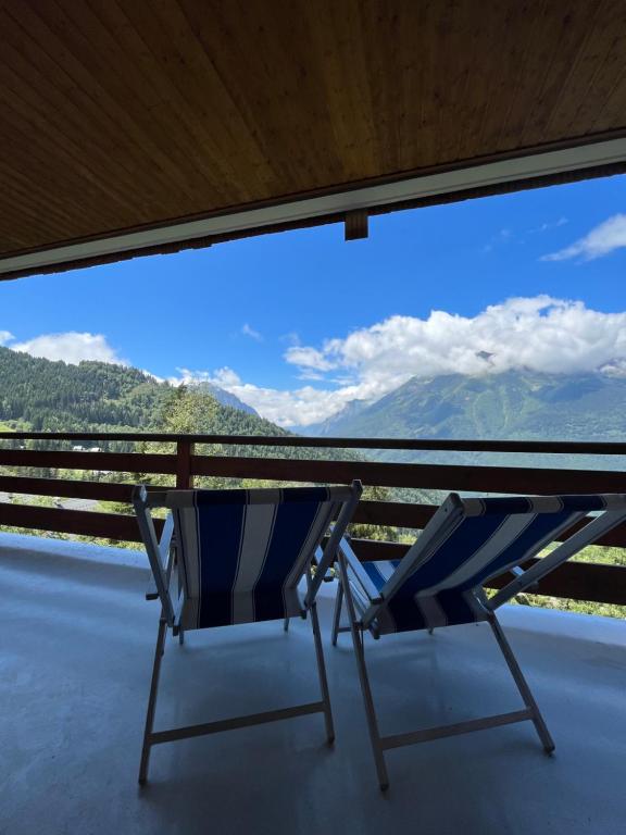 a blue chair sitting on a porch with a view at Apartment l’Alpette Oz en Oisans in Oz