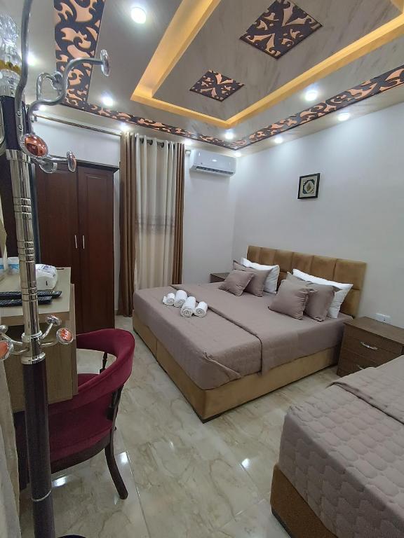 瓦迪穆薩的住宿－Petra downtown house，一间卧室配有两张床和椅子