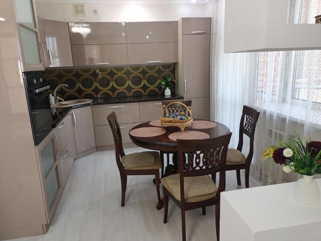 a kitchen with a table and chairs in a room at Трёхкомнатная квартира ВИП in Kokshetau