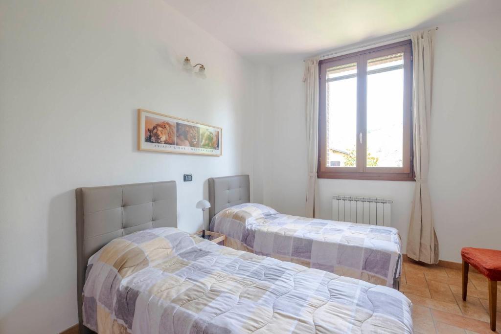 1 dormitorio con 2 camas y ventana en Stanza con due letti singoli Le Vitterelle, en Zocca