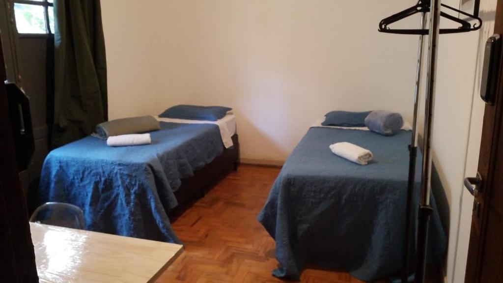 2 camas en una habitación con sábanas azules y toallas en Quarto Zen, en São Paulo