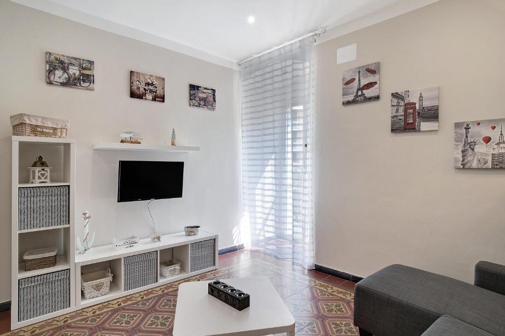 a living room with a couch and a flat screen tv at Casa Acqua Mare Parasio in Imperia