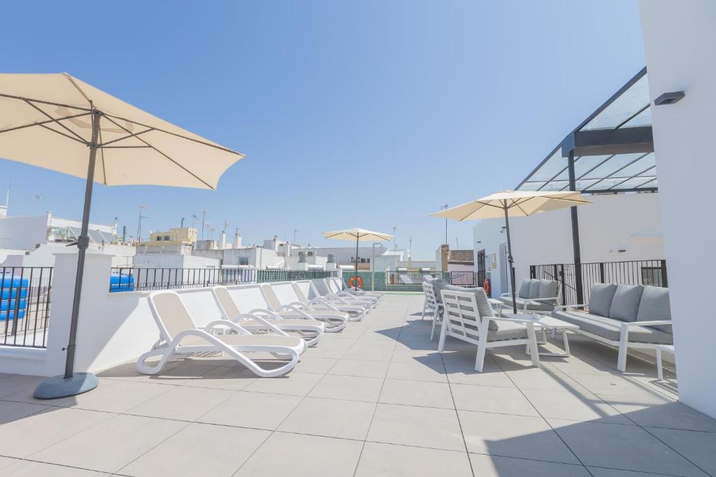 a row of chairs and umbrellas on a roof at Soho Boutique Cádiz in Cádiz