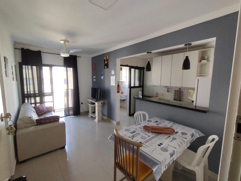 uma sala de estar com uma mesa e uma cozinha em Pérola Home - Guarujá no Guarujá