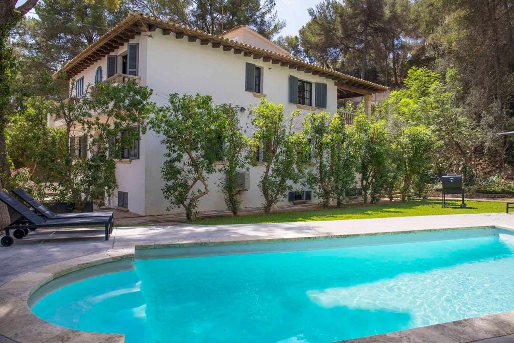 a villa with a swimming pool in front of a house at Villa Margarita in Palma de Mallorca