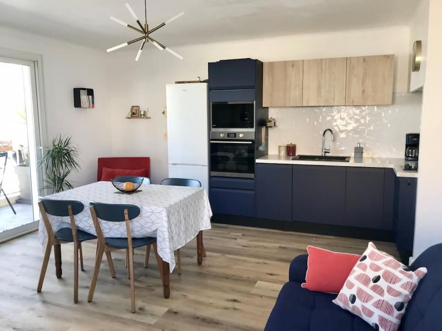 eine Küche und ein Esszimmer mit Tisch und Stühlen in der Unterkunft Direction Sud ! in Narbonne-Plage