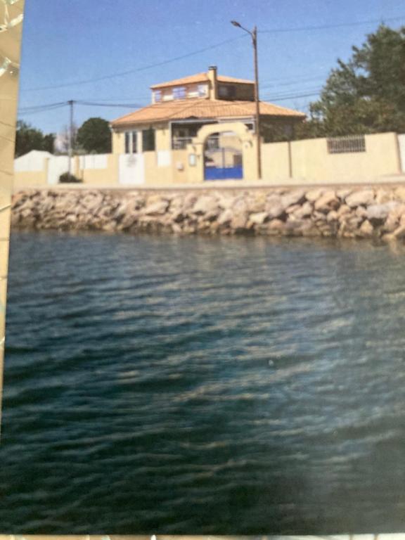 un grande bacino d’acqua con un edificio sullo sfondo di Studio Marseillan plage Robinson a Le Castellas