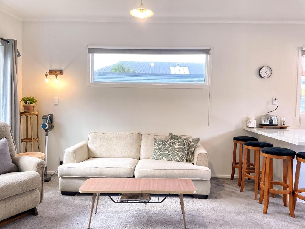 sala de estar con sofá y mesa en Cozy n Comfortable,5 mins to airport, en Wellington