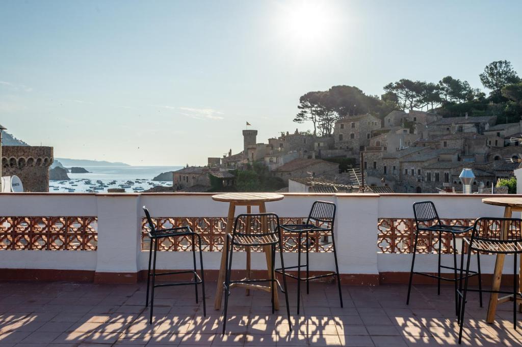 una mesa y sillas en un balcón con vistas en Hostal Boutique Es Menut en Tossa de Mar