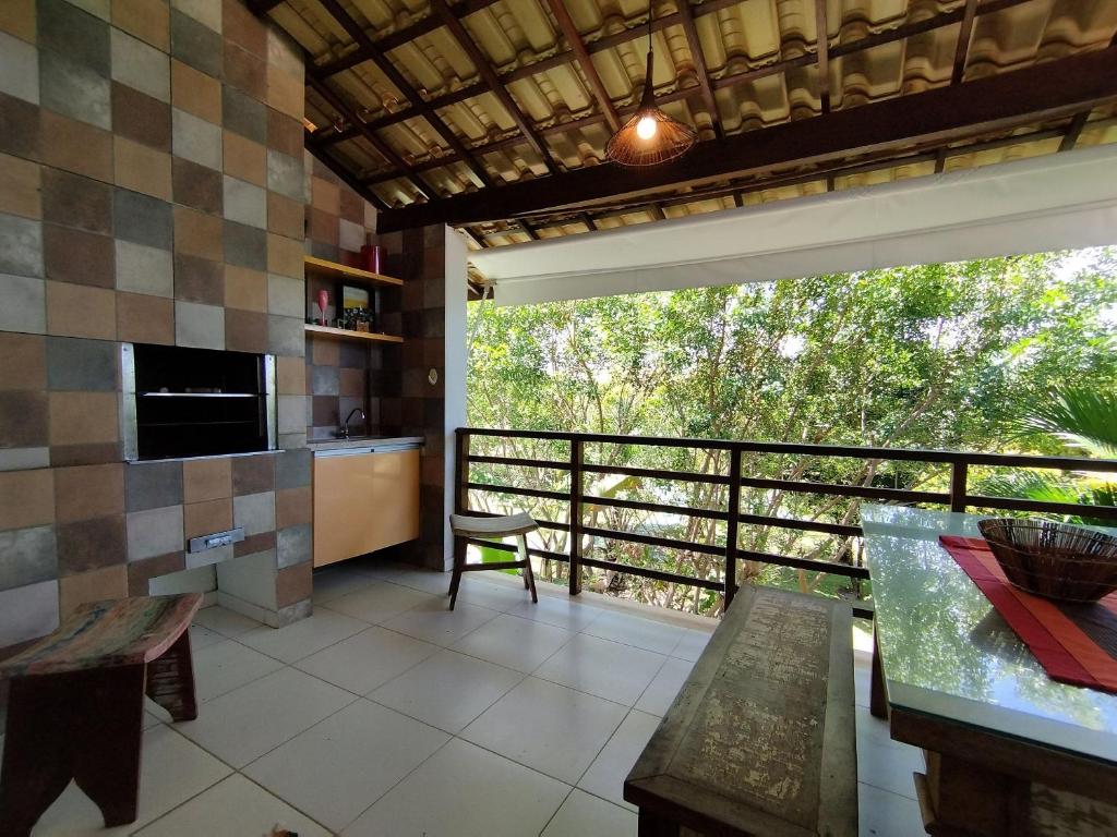 une chambre avec un balcon avec une table et une télévision dans l'établissement Reserva Imbassaí Apartamento 1 quarto área de churrasco Bl2202, à Mata de São João