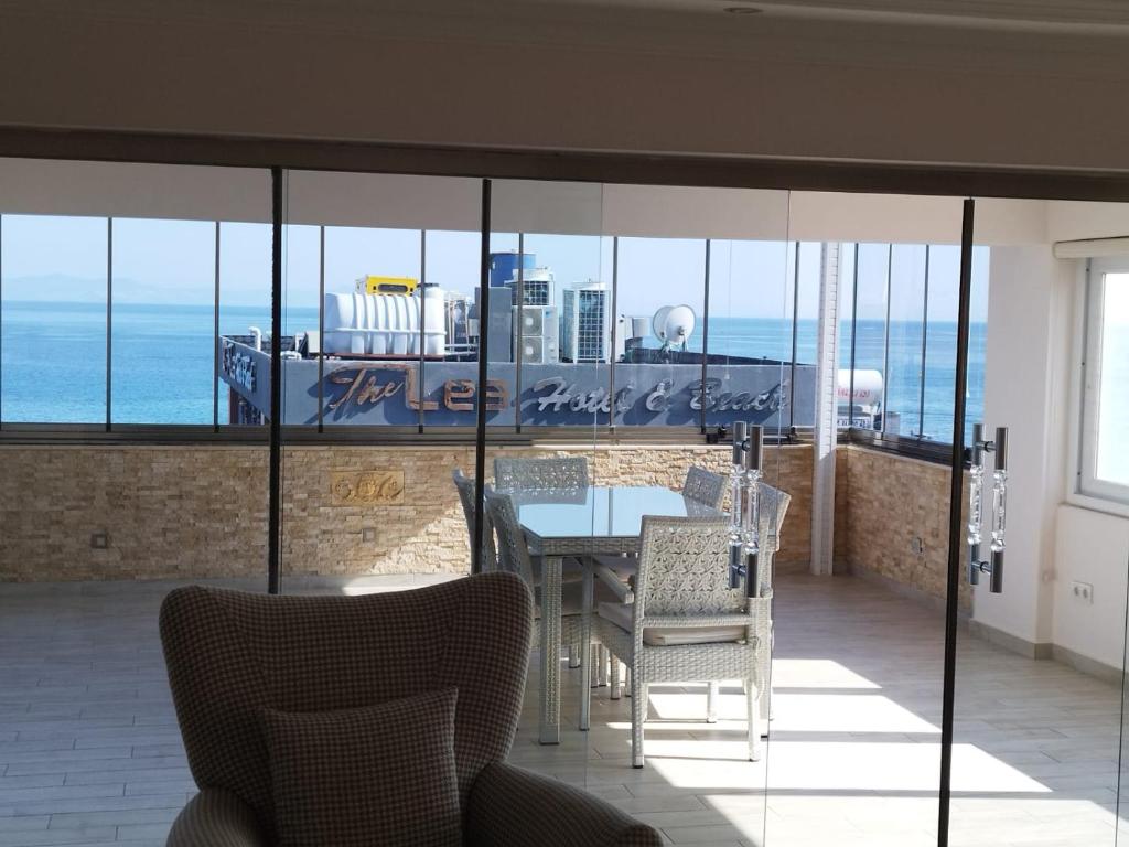 a dining room with a table and chairs and the ocean at ÖZLEM APART in Didim