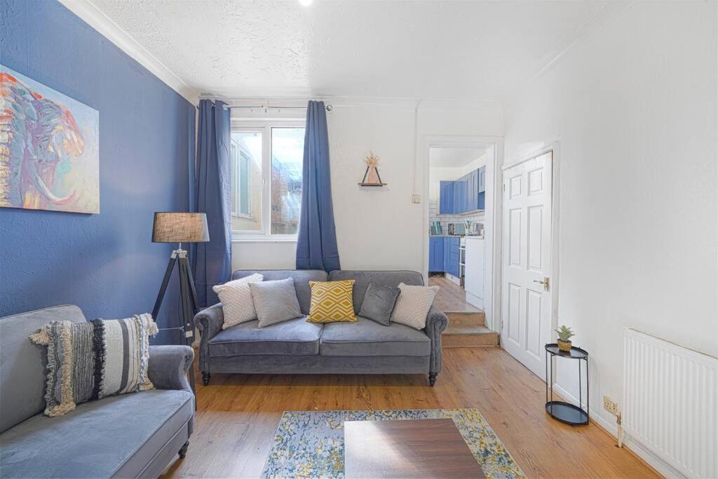 a living room with blue walls and a couch at Reve Bleu in Gillingham