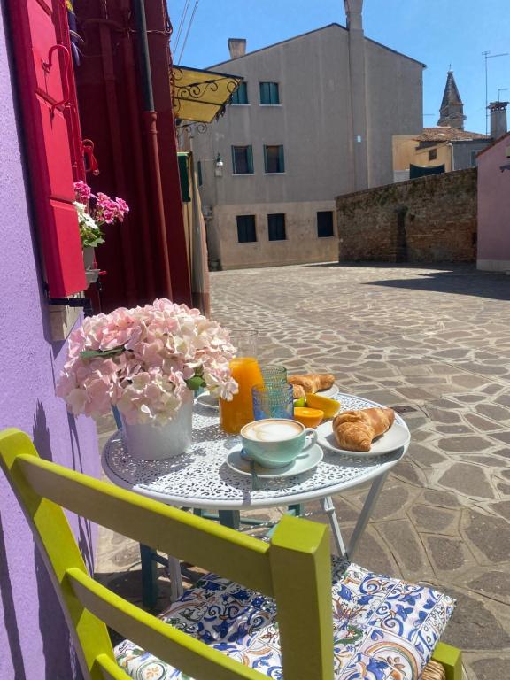 a table with a plate of food on a patio at Casa Bella in Burano