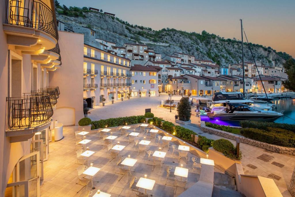 uitzicht op een hotel met 's nachts een jachthaven bij Tivoli Portopiccolo Sistiana Wellness Resort & Spa in Sistiana