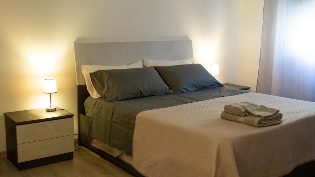 a bedroom with a bed with two towels on it at Like Home Apartment in Reggio Calabria
