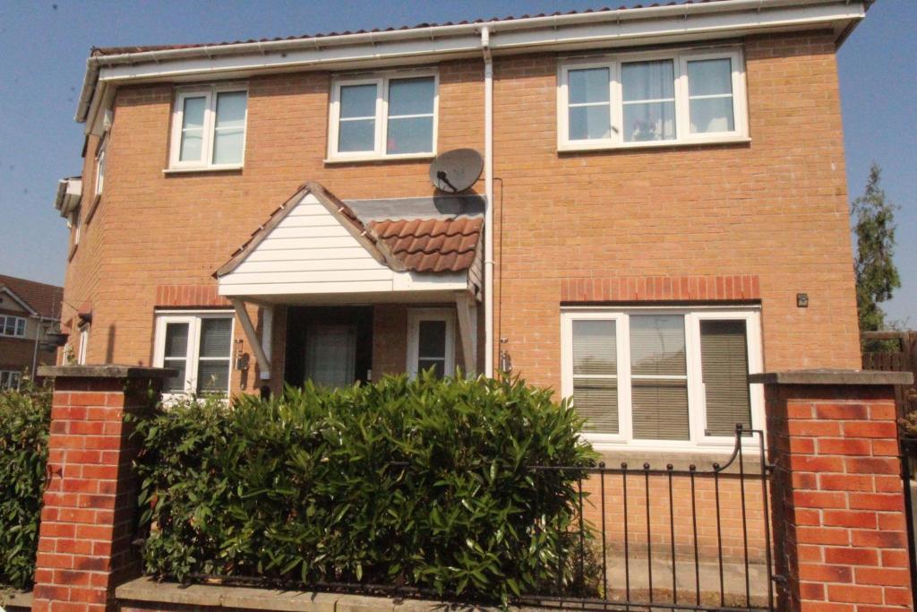 a brown brick house with a black fence at Stirling House in Sheffield