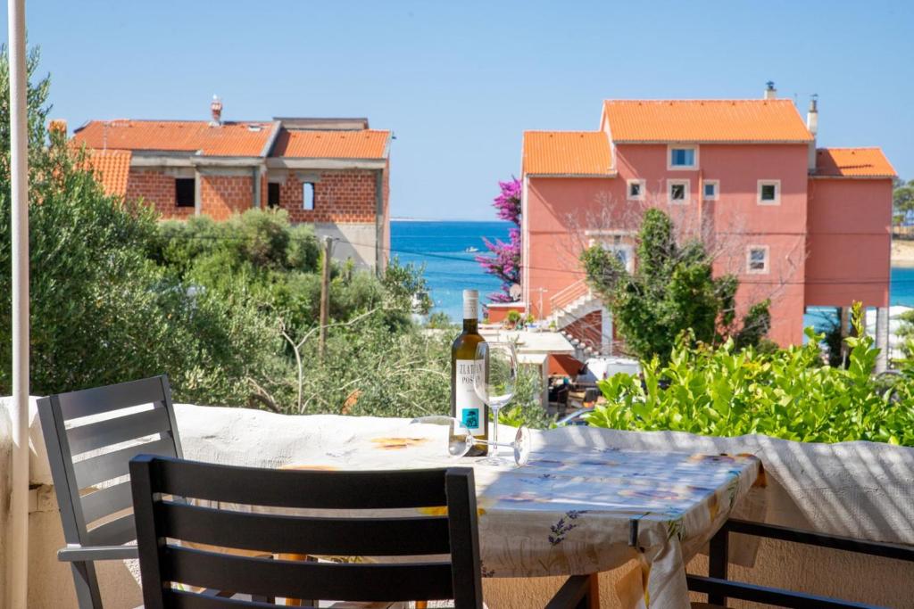 a bottle of wine sitting on a table on a balcony at Apartments Pende 3122 in Banjol