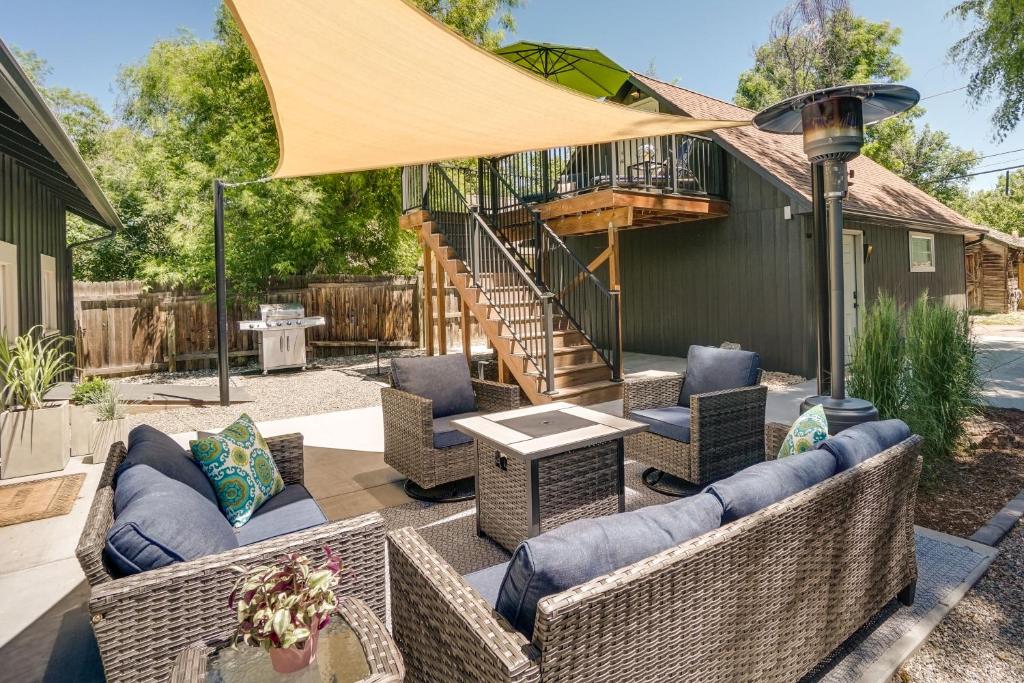 a patio with wicker furniture and a deck with a staircase at Old Town Carriage House with Private Patio in Fort Collins