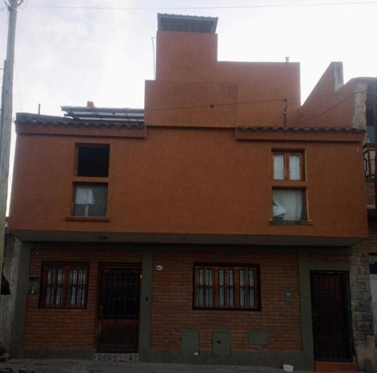 an orange brick building with windows on top of it at Hostal Tia Dora in San Salvador de Jujuy