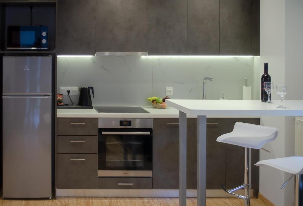une cuisine avec des appareils en acier inoxydable et un comptoir dans l'établissement Homey Comfort Apartments, à Athènes