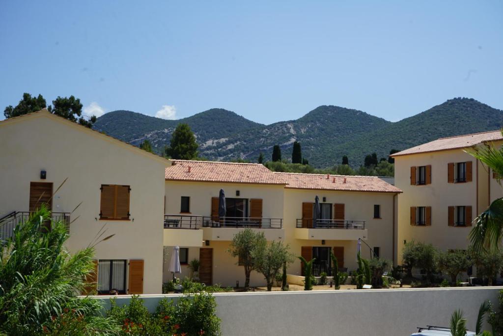 a row of houses with mountains in the background at Résidence CATALINA in Saint-Florent
