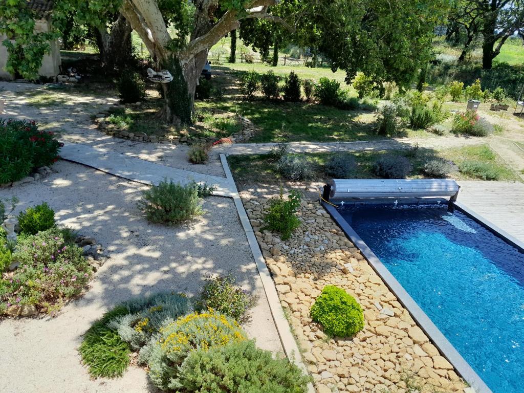 - une piscine avec un banc dans le jardin dans l'établissement Le mas Lou Caïroun, un paradis en Provence, à Aubignan