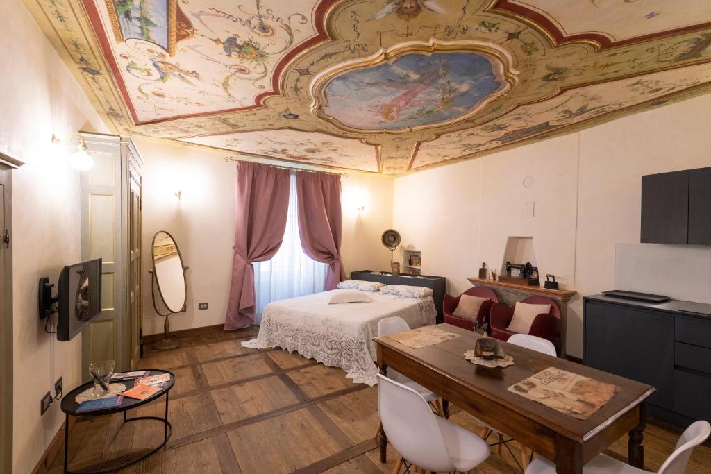 een slaapkamer met een bed en een plafond met een schilderij bij Maison Croix de Ville in Aosta