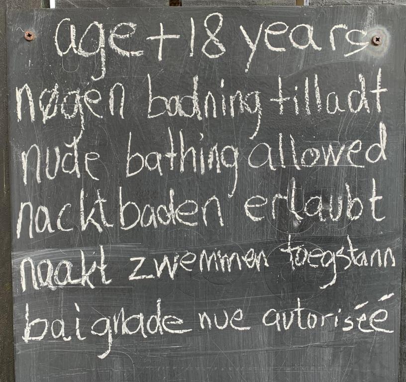 ein Schild mit Tafel und Aufschrift in der Unterkunft Farm61 badehotellet i det midtjydske - alder +18 år in Tjele