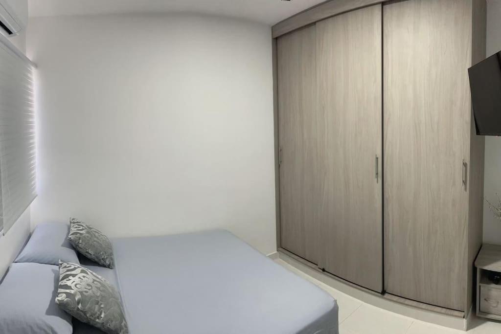 a bedroom with a bed and a cabinet at Apartamento muy cerca al Mar!-0k in Cartagena de Indias