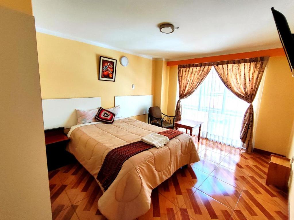 Habitación de hotel con cama y ventana en SUMAQ PUNO, en Puno