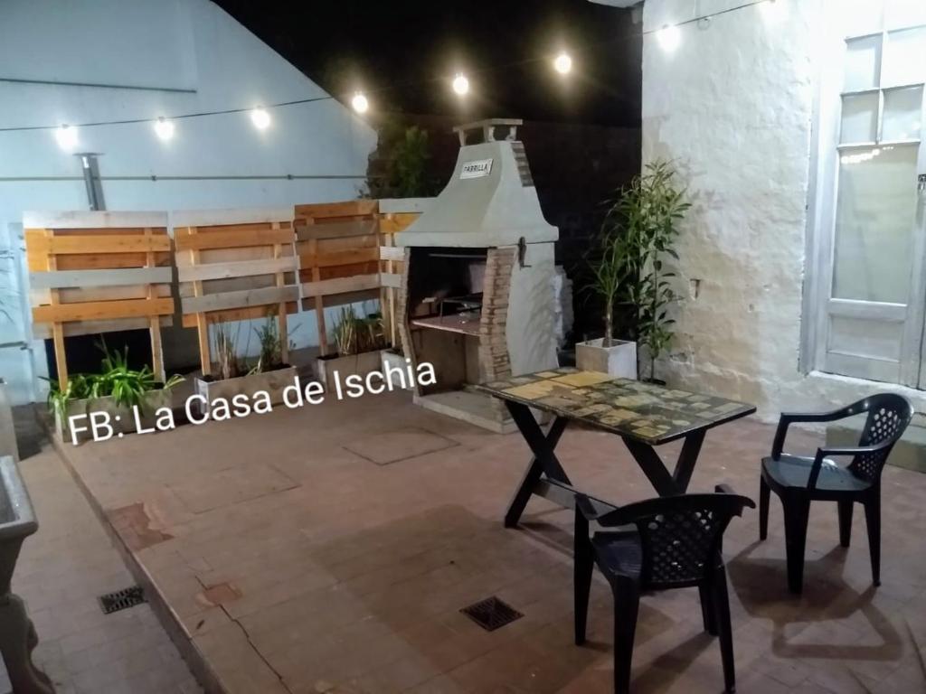 a room with a table and chairs and a fireplace at La Casa de Ischia in Mar del Plata