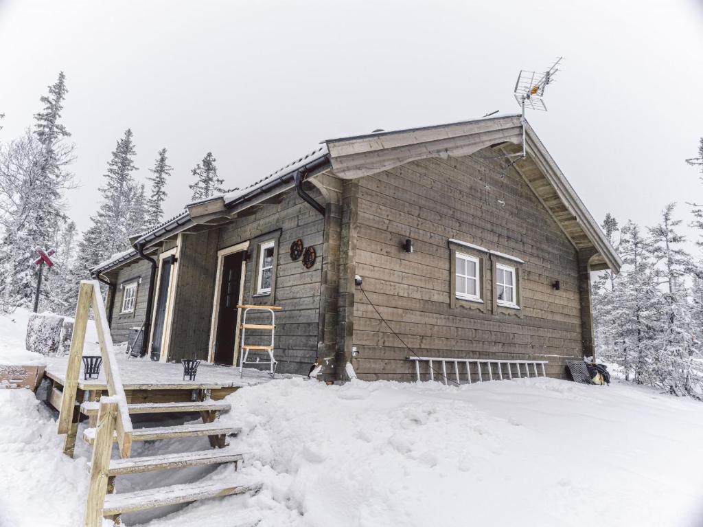 una piccola casa in legno nella neve con la neve di Modern holiday cottage in Are a Undersåker