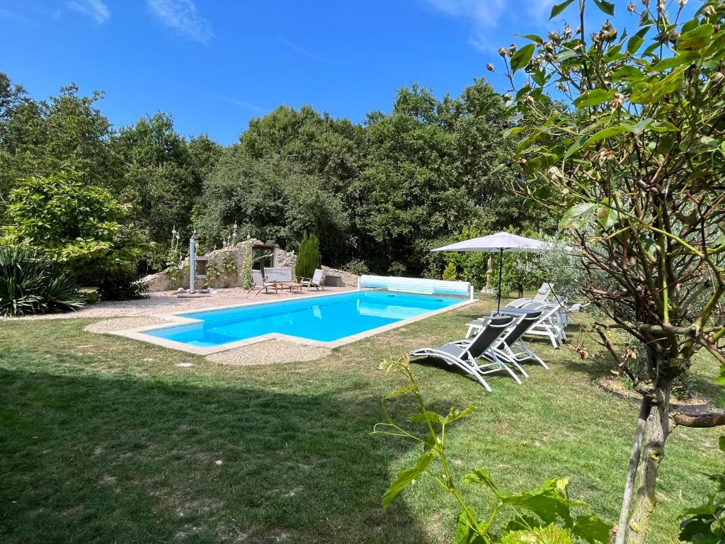 a pool in a yard with chairs and an umbrella at Les gîtes de La Pellerie - 2 piscines &amp; spa Jacuzzi - Touraine - 3 gîtes - familial, calme, campagne in Saint-Branchs