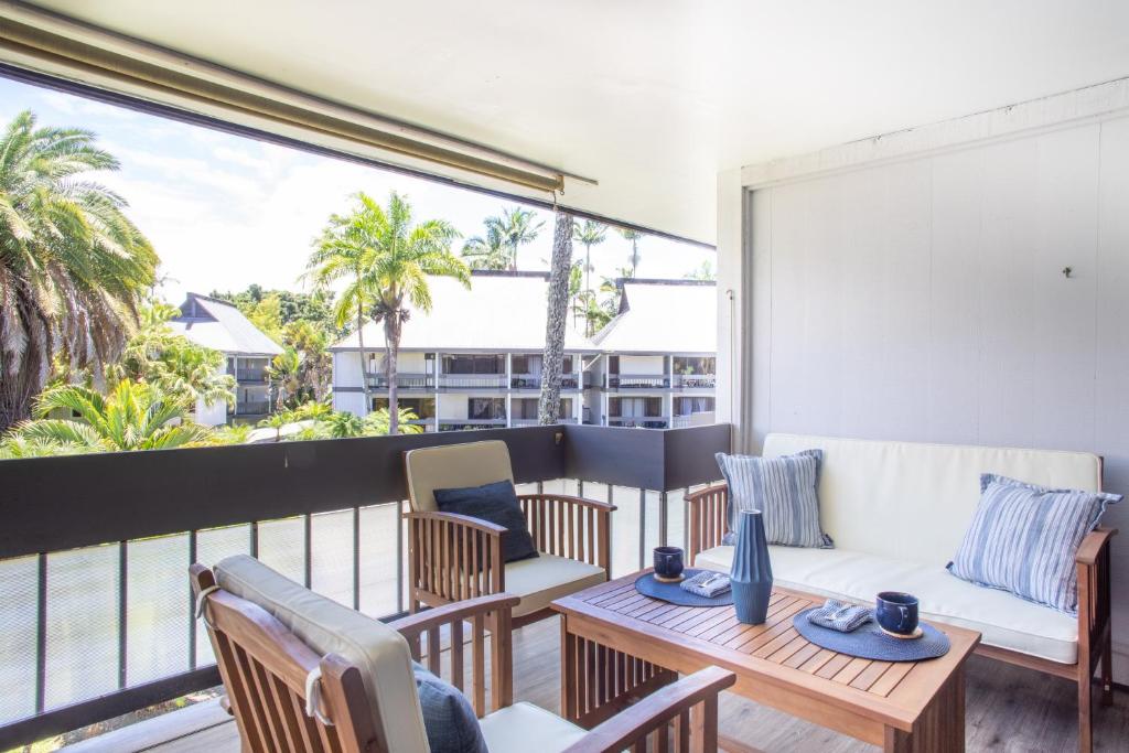 balcón con sofá, sillas y mesa en Waiakea Villas 4329 condo, en Hilo