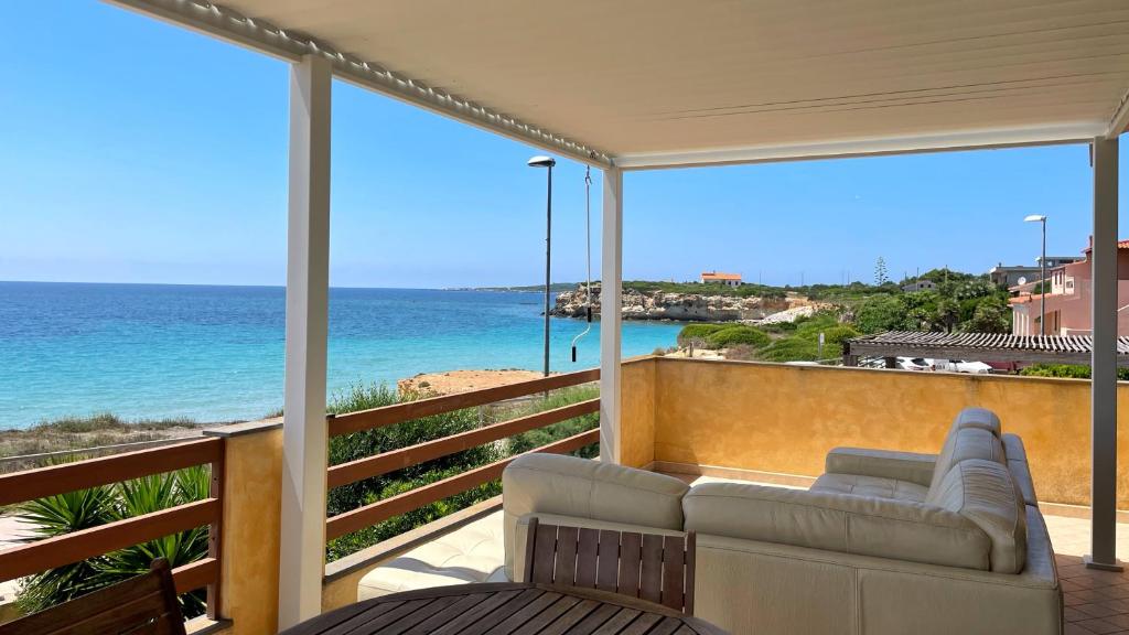balkon z kanapą i widokiem na ocean w obiekcie Welcomely - Casa Dei Marinai w mieście Putzu Idu