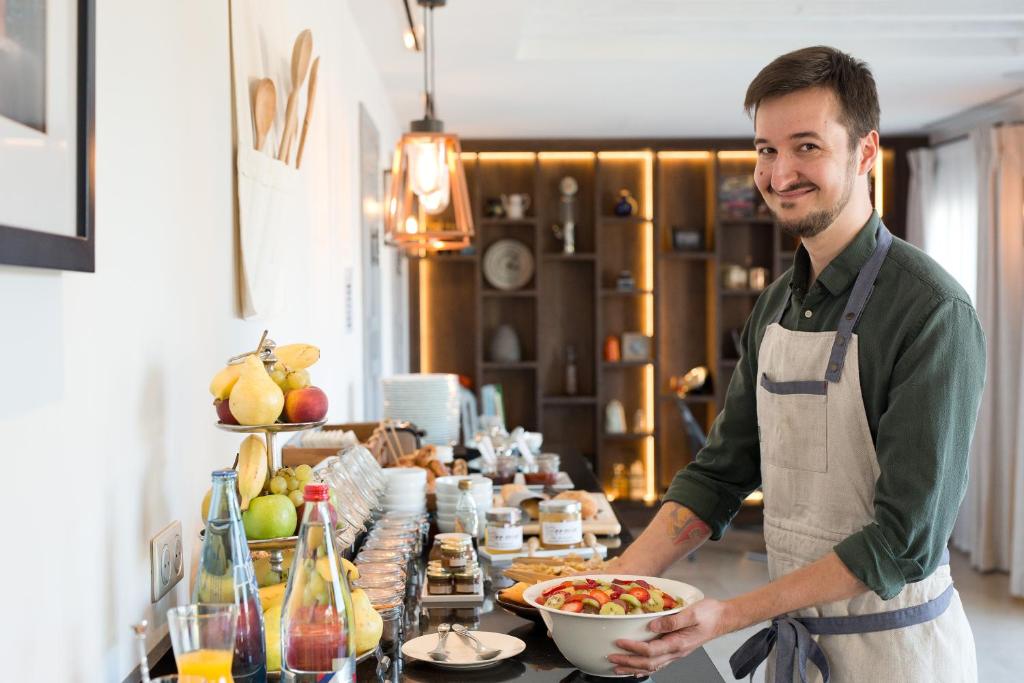 a man in a kitchen holding a bowl of food at La Bastide de Biot in Biot