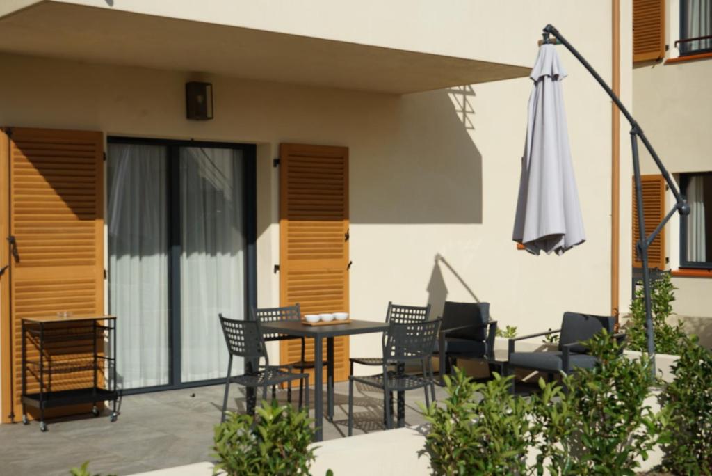 a patio with a table and chairs and an umbrella at Résidence CATALINA in Saint-Florent