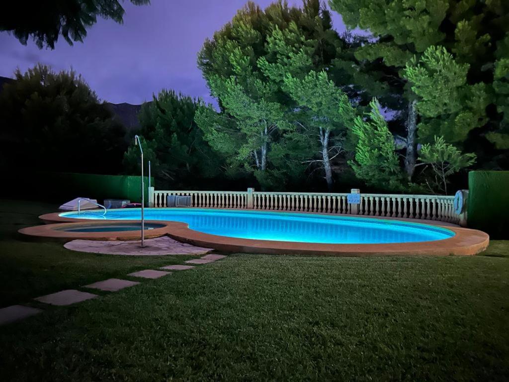 a swimming pool in a yard at night at Casa Feliz in Beniarbeig