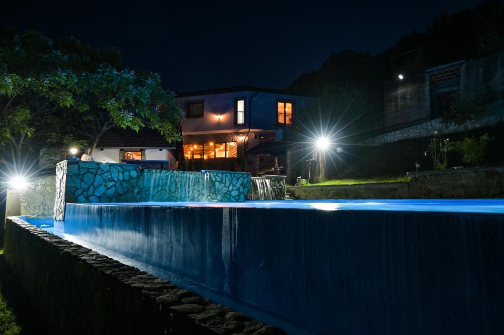 a house with a swimming pool at night at Konoba Slapovi in Jajce