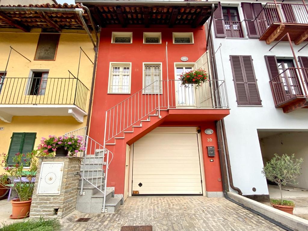 Montà的住宿－loft39 Roero，一座红色和白色的建筑,设有车库