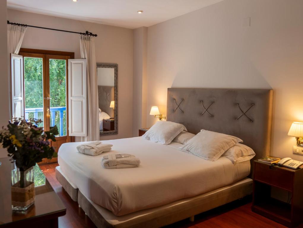 sypialnia z dużym łóżkiem i dwoma ręcznikami na nim w obiekcie Hotel Rural Spa Don Juan de Austria w mieście Jarandilla de la Vera