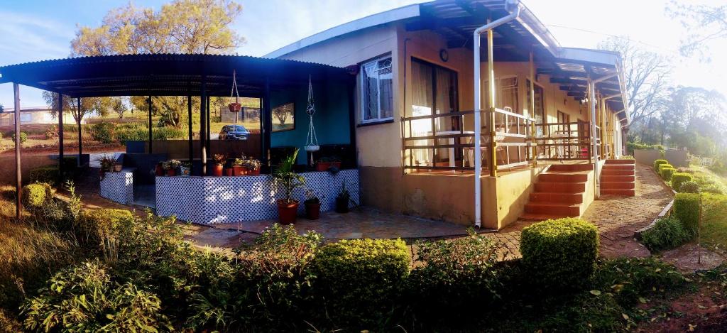 una pequeña casa con techo azul y porche en Otentik guesthouse, en Mbabane