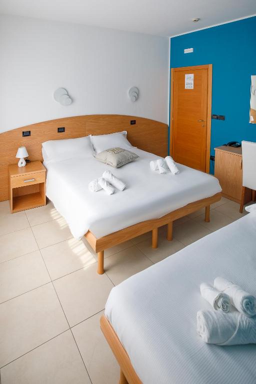 A bed or beds in a room at Hotel Hc Resort Lignano