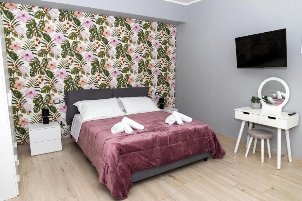 a bedroom with a bed with a floral wallpaper at Le stanze di Dalia in Crotone