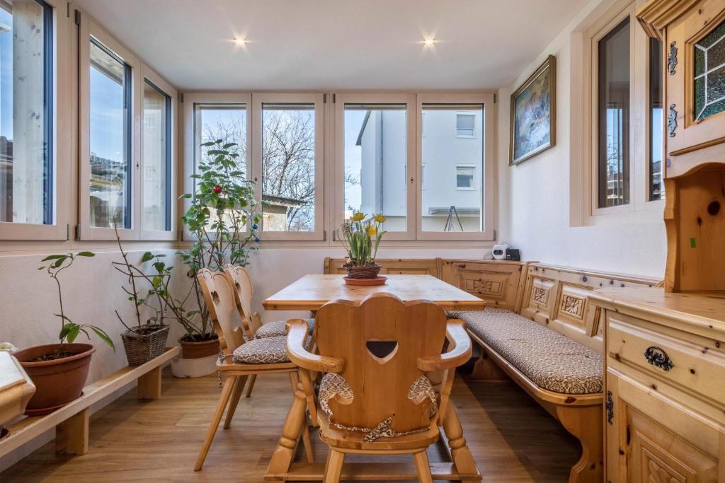 - une cuisine avec une table en bois, des chaises et des fenêtres dans l'établissement Ferienwohnung Tannenblick, à Höchst