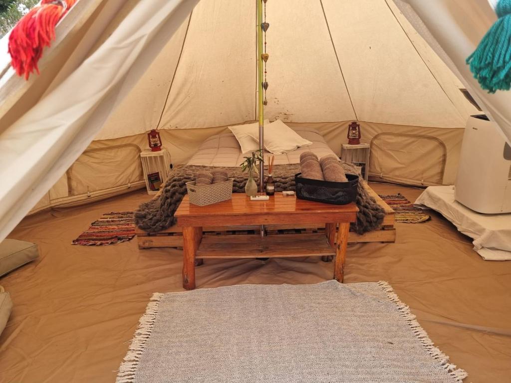 Una habitación con una tienda con una mesa. en GLAMPING RANCHO ALEGRE en Merlo